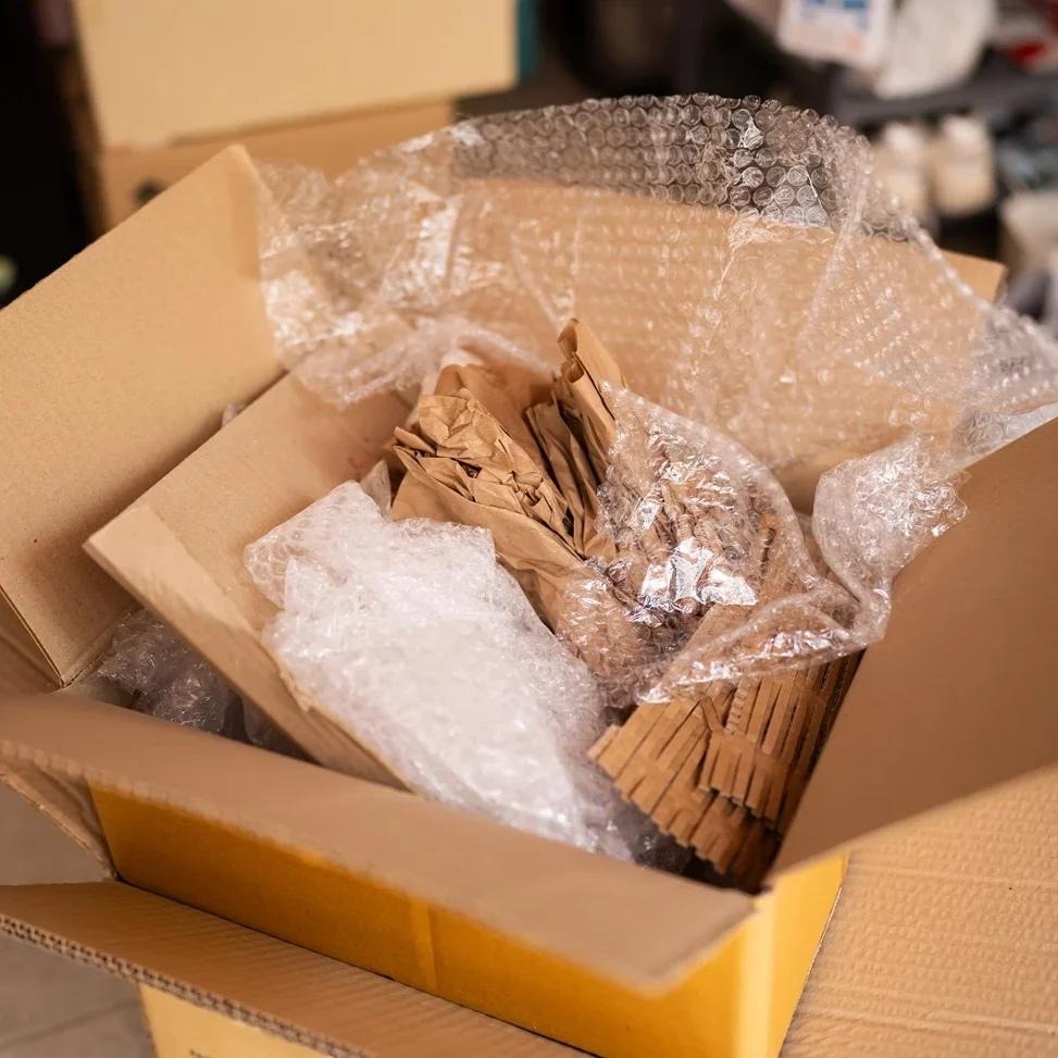 Open carton stuffed with a mix of bubble wrap and crumpled kraft paper